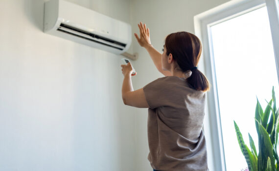 Woman turning on air conditioner